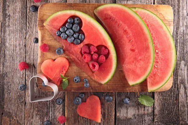 Арбуз с ягодами на столе — стоковое фото