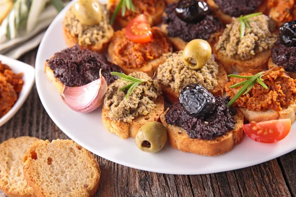 Канапе с тапенадой и оливками — стоковое фото
