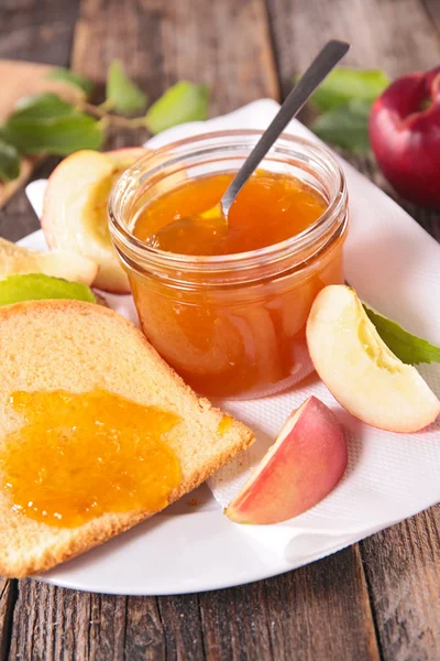 Peach jam in jar and on bread — Stock Photo, Image