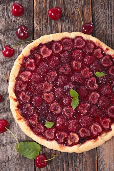 Cherry tart with mint on wood