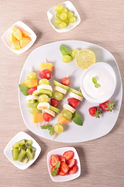 Vruchten op stokken met duik van yoghurt — Stockfoto