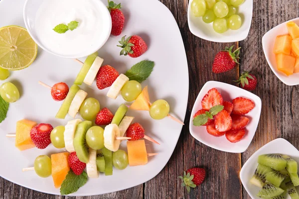 Fruits on sticks with dip of yogurt — Stock Photo, Image