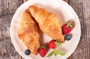 kruvasan ve çilek plaka üzerinde