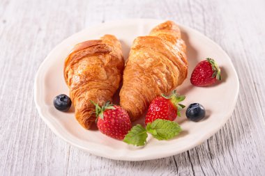 kruvasan ve çilek plaka üzerinde