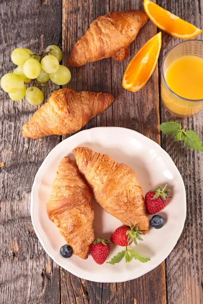 Croissants, orange juice, fruits — Stock Photo, Image