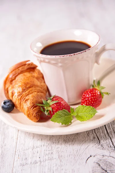 Чашка кофе, круассан и ягоды — стоковое фото