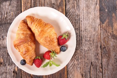 kruvasan ve çilek plaka üzerinde