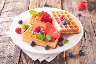 Waffles and berry fruit in white plate