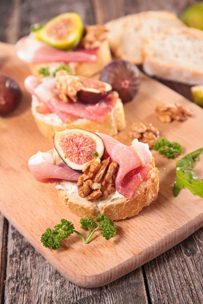 Bread with cheese, prosciutto and fig — Stock Photo, Image