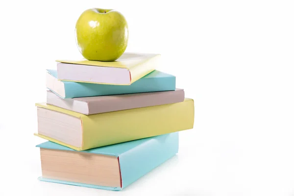 Libros y manzana verde sobre blanco — Foto de Stock