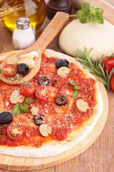 Pizza and ingredients on table — Stock Photo, Image