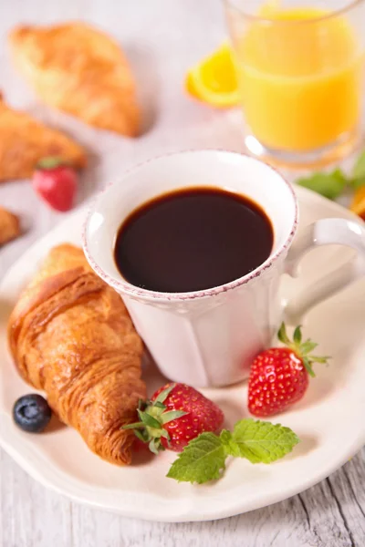 Чашка кофе, круассан и ягоды — стоковое фото