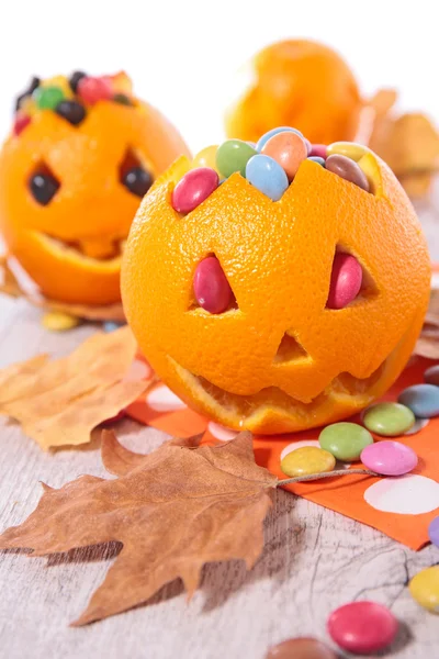 Naranjas de halloween con caramelos —  Fotos de Stock