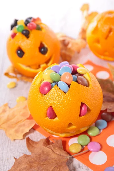 Addobbi di Halloween, arance con caramelle — Foto Stock