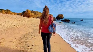 Kumsalda yürüyen kadın, Portekiz 'de Algarve.