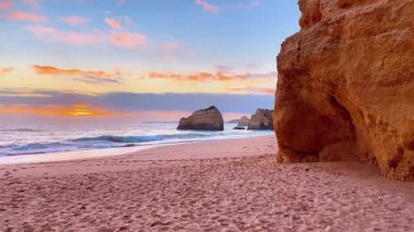 Sahilde gün batımı, kayalıklı güzel Algarve plajı, Portekiz.