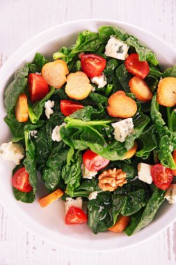 Kızarmış ekmek, peynir, ceviz ve domatesli ıspanak salatası.