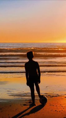 Sahilde gün batımına bakan toplu çocuk silueti, sosyal medya için dikey video.