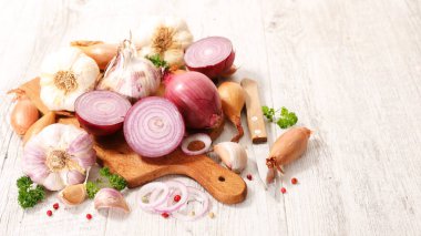 Tahtada taze sarımsak ve soğan var.