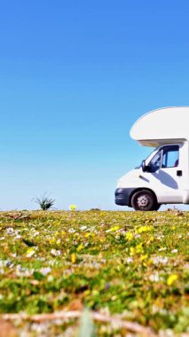 Kamp aracı çimenli araziye park edilmiş.