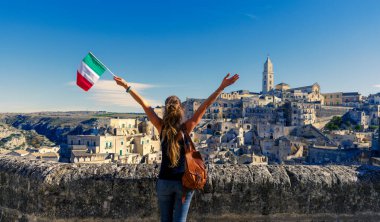 İtalya 'nın güneyindeki Basilicata bölgesinde panoramik manzara seyreden İtalyan bayrağı taşıyan kadın.