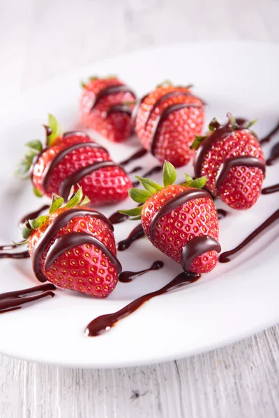 Strawberries dipped in chocolate sauce — Stock Photo, Image