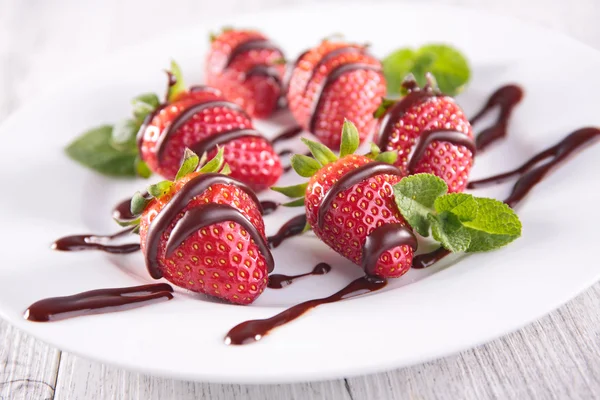 Strawberries dipped in chocolate sauce — Stock Photo, Image