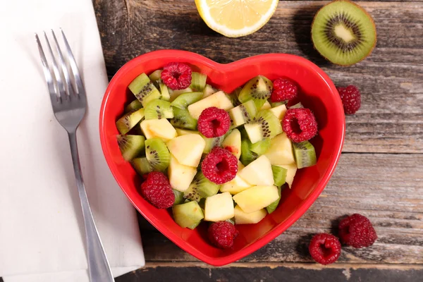 Fruit salad in heart bowl — Stock Photo, Image