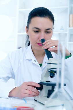 Bir laboratuarda mikroskop ile çalışan kadın. Tonlama resim