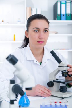 Bir laboratuarda mikroskop ile çalışan kadın. Tonlama resim