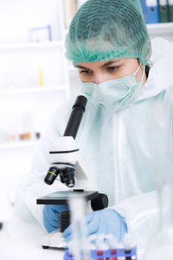 Bir laboratuarda mikroskop ile çalışan kadın. Tonlama resim