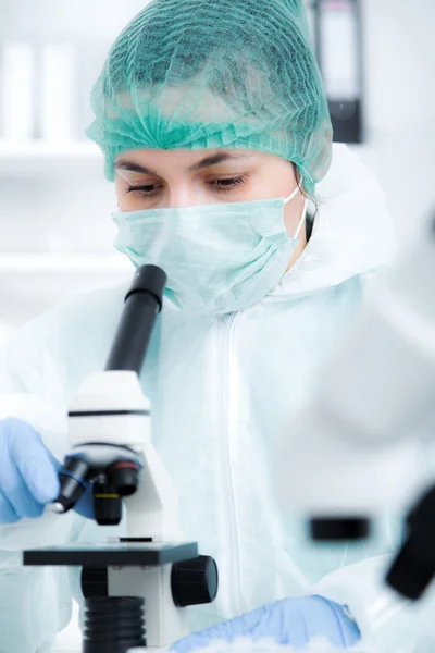 Vrouw die werkt met een microscoop in een lab. Verstevigende afbeelding — Stockfoto