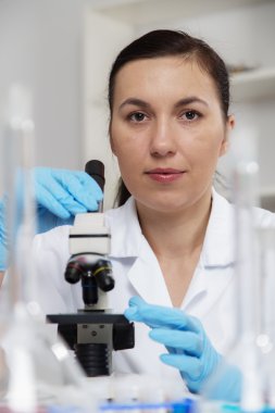Bir laboratuarda mikroskop ile çalışan kadın. Tonlama resim