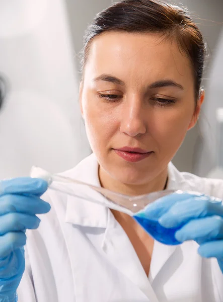 Scientist examining solution in petri dish at a laboratory — Stock Photo, Image