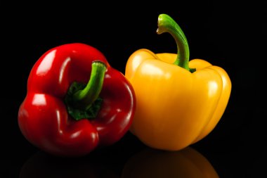 taze kırmızı ve sarı biber. siyah bir arka plan üzerinde