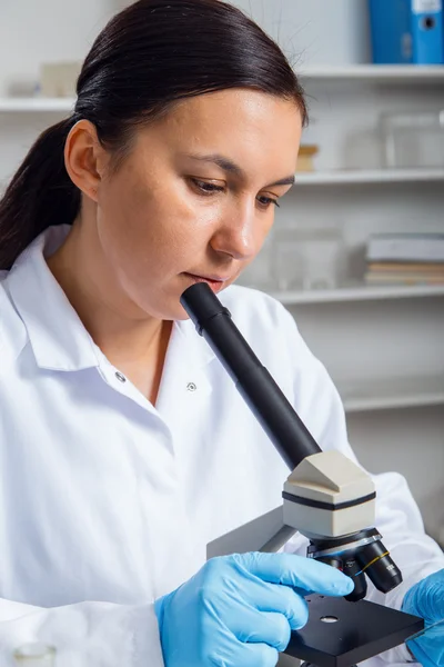 Donna che lavora con un microscopio in laboratorio . — Foto Stock