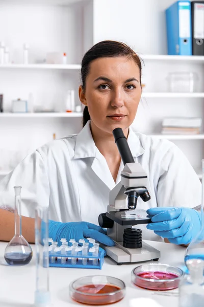Kobieta praca z mikroskopem w laboratorium. — Zdjęcie stockowe