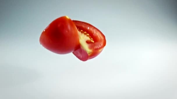 Pomidor przepływu z zwolnionym tempie ponad White.tomato strzelanie z kamera o dużej szybkości. — Wideo stockowe