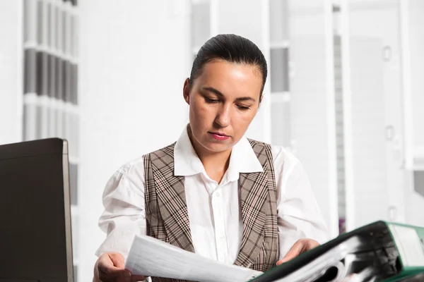 Jeune femme d'affaires assise sur le lieu de travail et travaillant avec des papiers au bureau — Photo