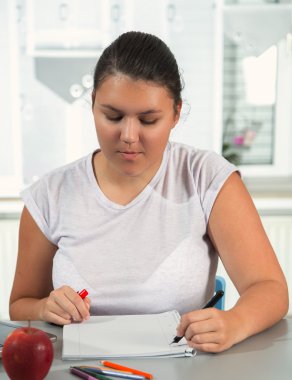 güzel bir kız evde okul projesi üzerinde çalışıyor.