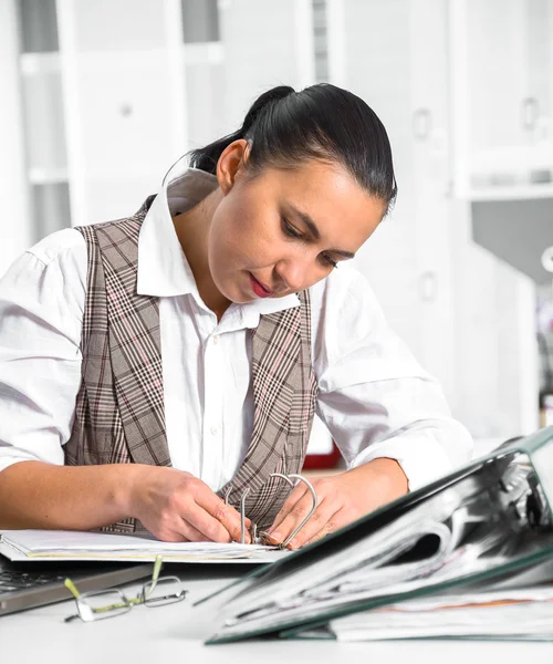 Jeune femme d'affaires assise sur le lieu de travail et travaillant avec des papiers — Photo