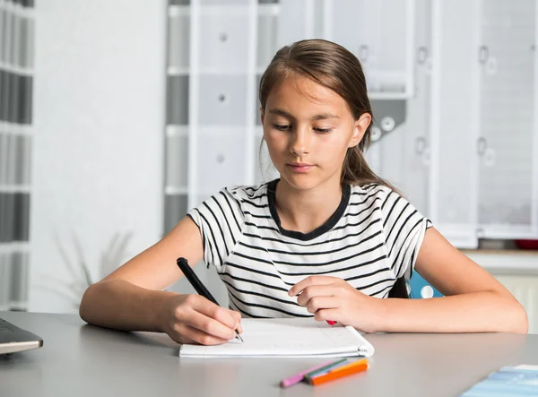 Mooi meisje op haar schoolproject thuis werken. — Stockfoto