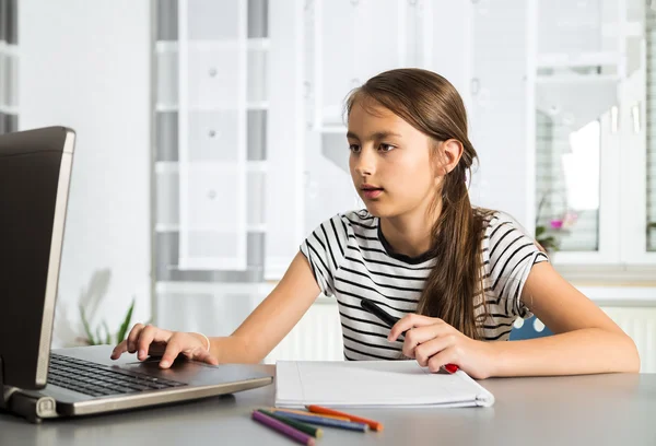 Menina bonita trabalhando em seu projeto escolar em casa . — Fotografia de Stock