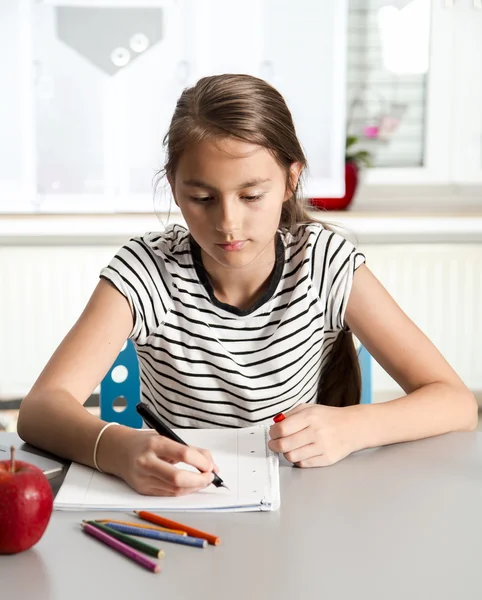 Menina bonita trabalhando em seu projeto escolar em casa . — Fotografia de Stock