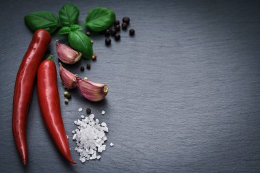 Kırmızı biber, kuru biber, siyah taş tabakta sarımsak. Yemek fotoğrafı arkaplanı