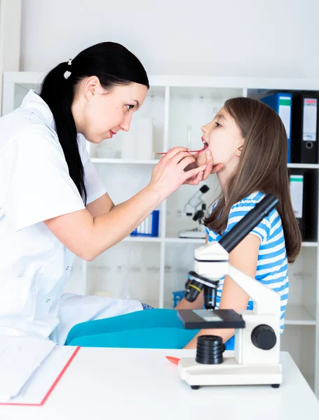 Läkare kontrollera halsen av liten flicka — Stockfoto