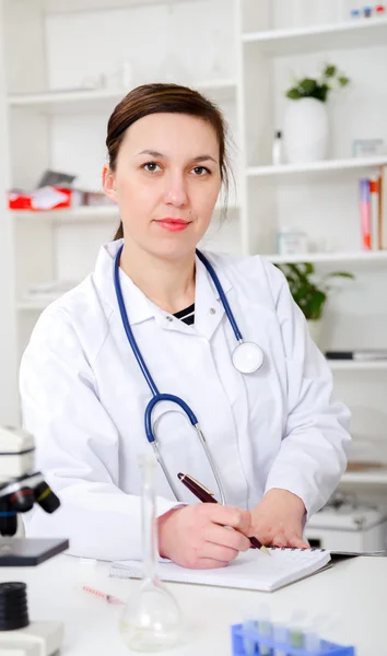 Kvinnliga läkare skriver recept på kliniken — Stockfoto