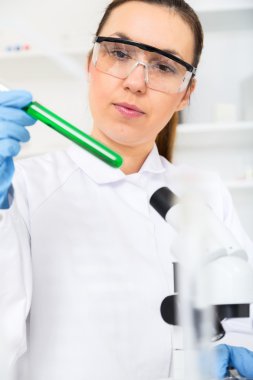 Kimyager kadın laboratuarda sıvı testi yapıyor.