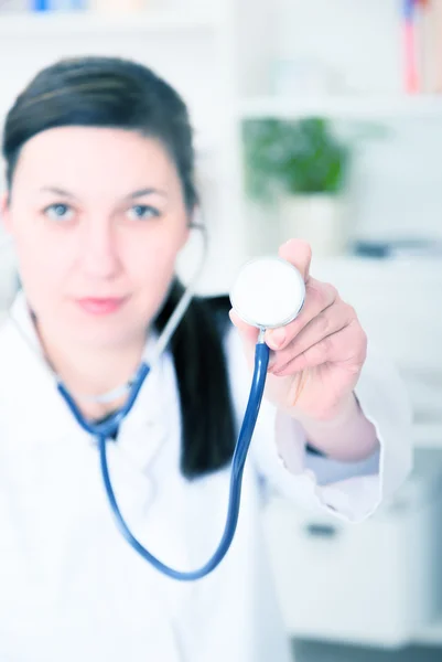 En kvinnlig läkare med stetoskop lyssnar — Stockfoto