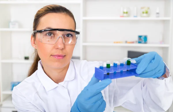 Kemist kvinna testa prov av vätska i laboratorium — Stockfoto